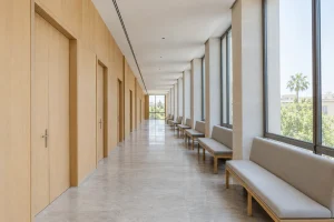Pasillo luminoso de unos juzgados con bancos vacíos frente a las salas de vistas: qué pasa si no puedes asistir a un juicio
